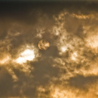 雲に霞む夕日