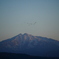 夕陽を浴びる鳥海山と寝床に戻る鳥たち