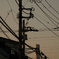 煙突と煩雑なケーブル類が見える夕景