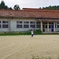 白い木造校舎とテニスで遊ぶ児童