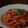 ベーコンとトマトのパスタにバジルを添えて