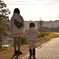 夕暮れ時、川沿いの姉妹。