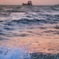 船と夕陽と波しぶき