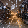 金色に染まる三町に雪が舞う
