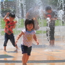 水で遊ぶ男の子、水から逃げる女の子。