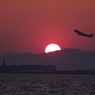 夕日を背景に関空から離陸するB747