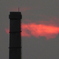 隅田川の煙突の後ろの雲間に消える夕日