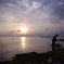 沖縄竹富島にて 海藻取りをするおじいと夕日