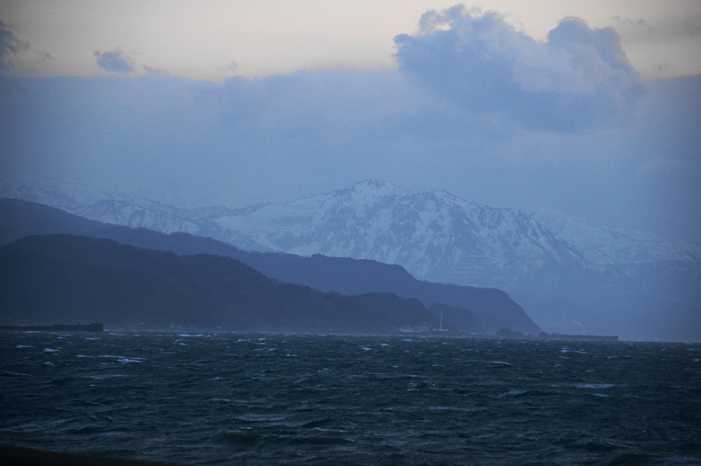 吹く海に雪山