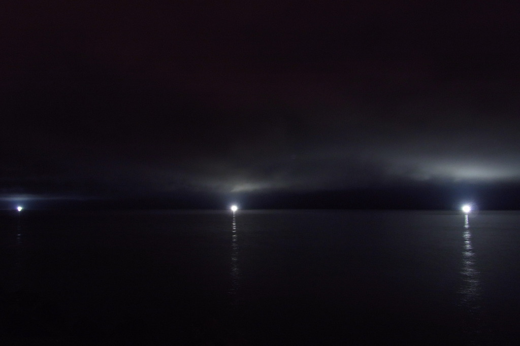 雲と海に照る漁火