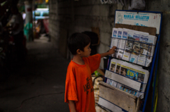 台風被害を新聞で知る少年