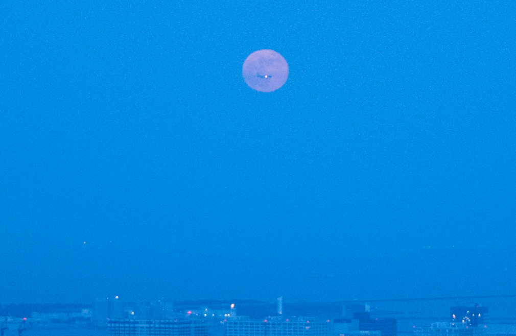 初めて撮れた満月の中にジェット機