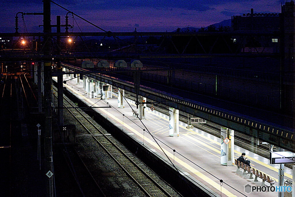 駅のホームで電車を待つ人