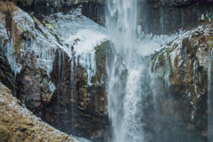 厳しく華やかな滝を浴びる