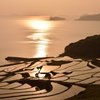 海と棚田を照らす夕日