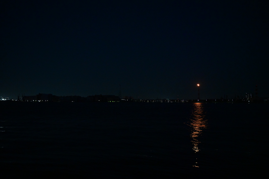夜の海とガスの灯り。