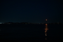 夜の海とガスの灯り。