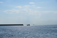 快晴の海と防波堤と船。