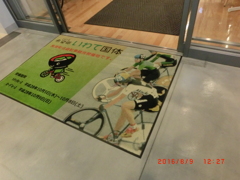 図書館入り口に自転車広告絨毯