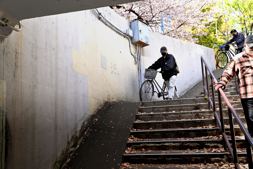 電車道をくぐる人々