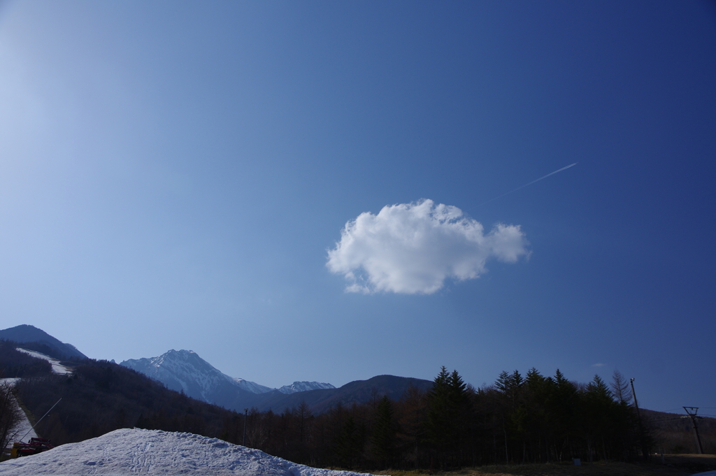 初春の雪山と雲と飛行機雲