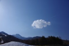 初春の雪山と雲と飛行機雲