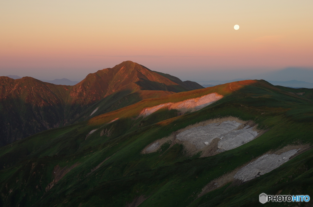 朝陽浴びる山と月