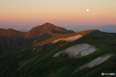 朝陽浴びる山と月