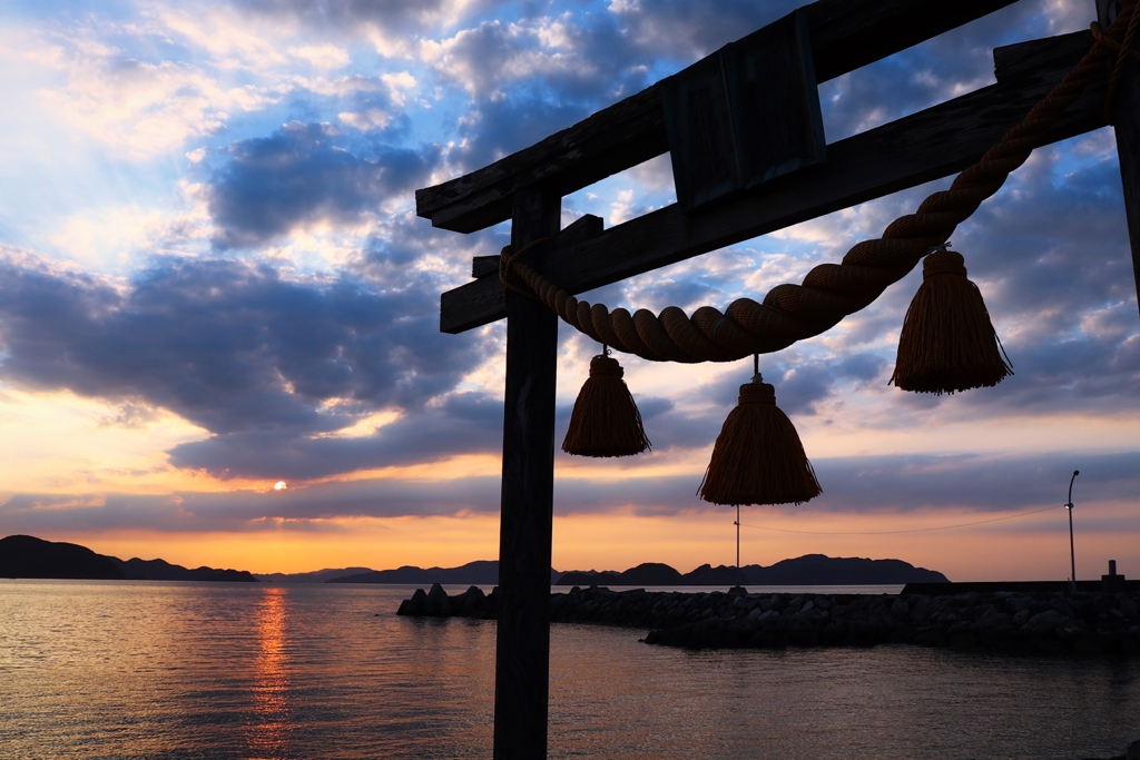 しめ縄と前垂れ越しの夕景