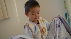 寝ぼけながら毛布たたむ