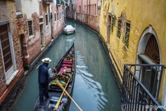 ヴェネツィアの小運河を漕ぐゴンドラ