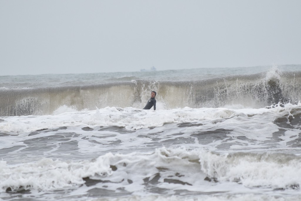 波をバックにキリッ