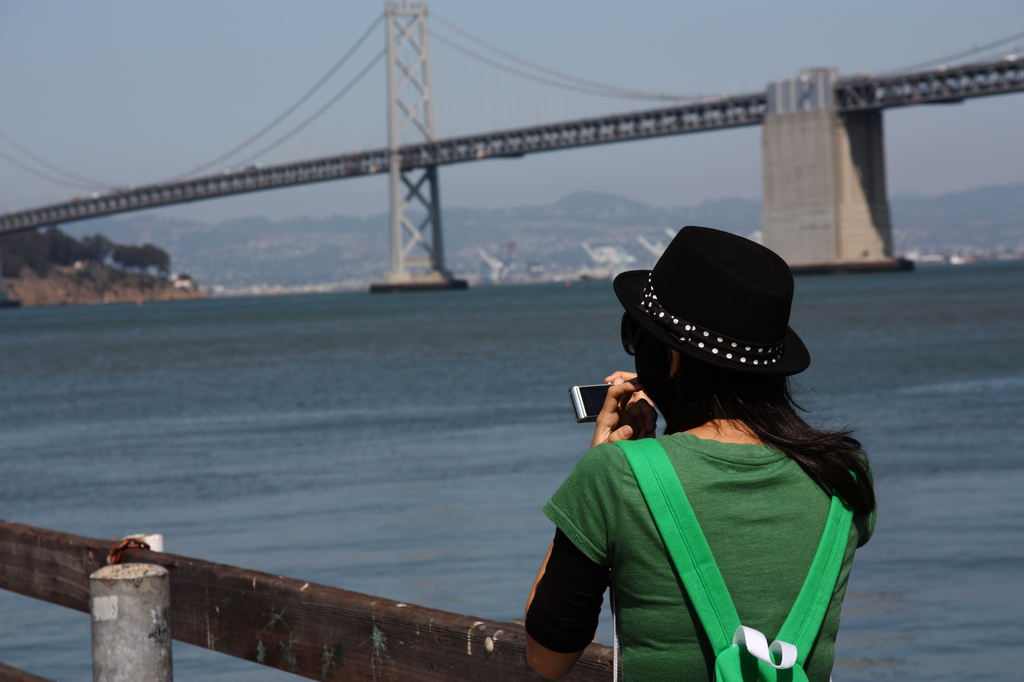 a girl taking a picture of SF bay