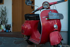 With a red Vespa