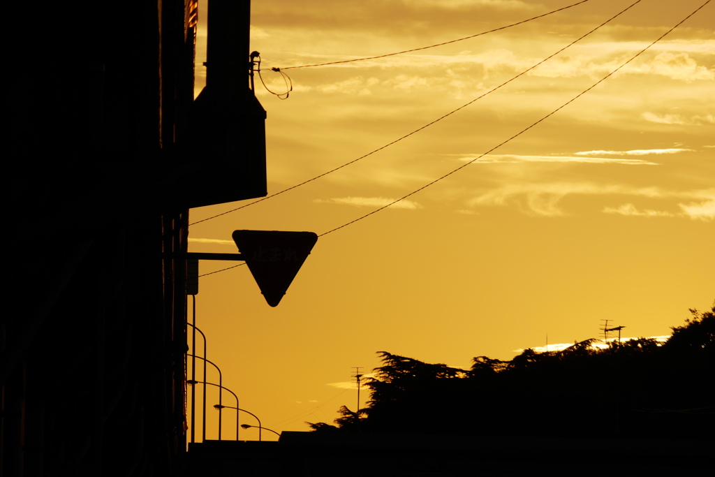 「止まれ」の標識と夕空