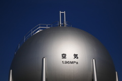 蒼い空の下で銀色に輝く空気(真空)のタンク