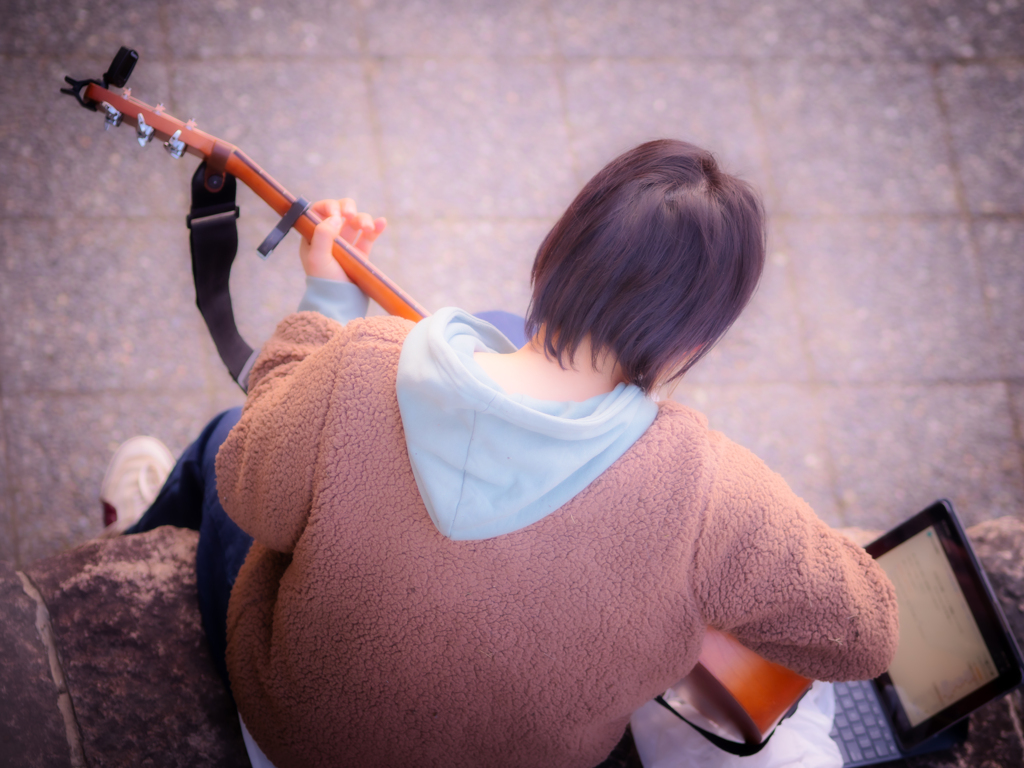 パソコン見ながら弾き語る