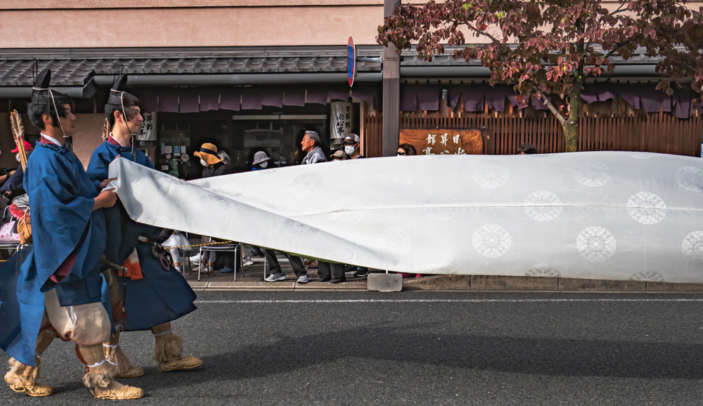 帯の長い人の帯を持つ人