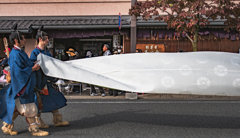 帯の長い人の帯を持つ人