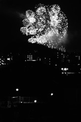 近くの歩道橋の灯りと遠くの花火の灯り