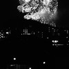 近くの歩道橋の灯りと遠くの花火の灯り