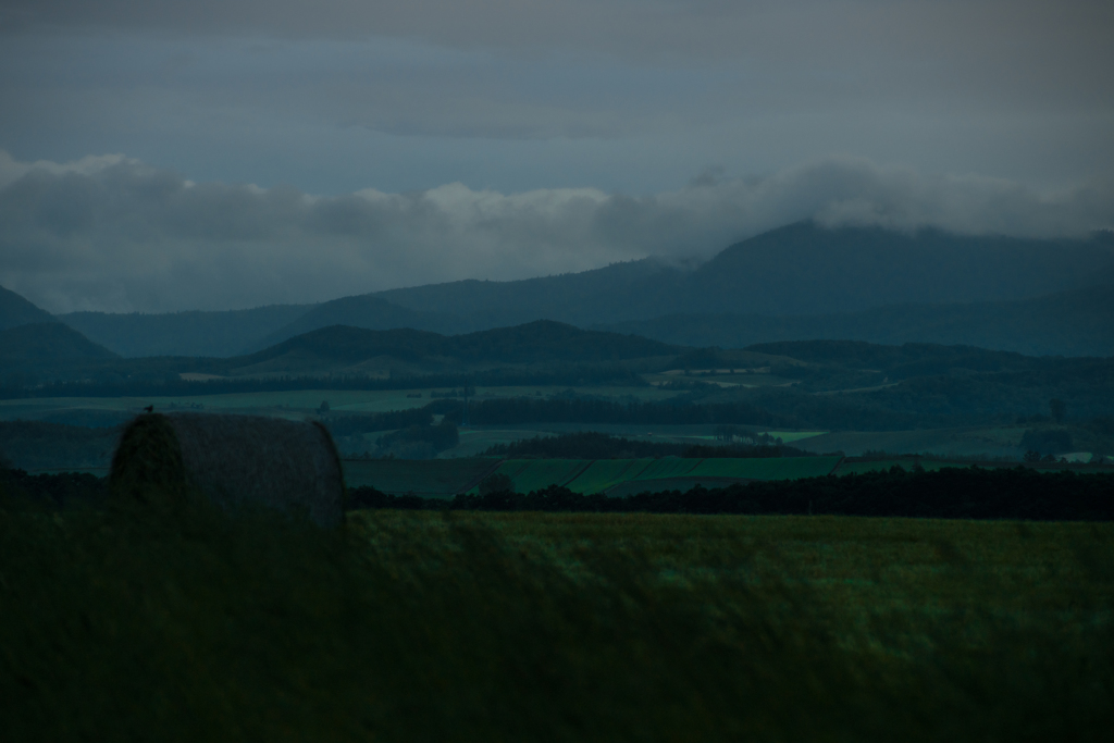 暮れ行く丘と牧草ロール