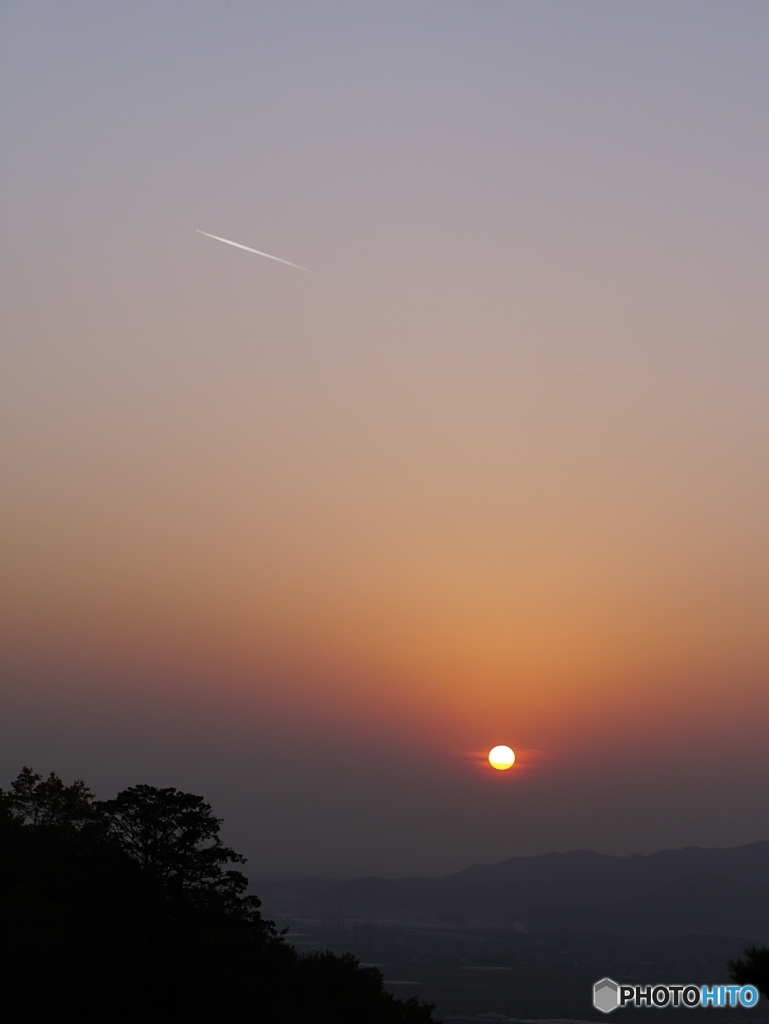 飛行機雲と落日