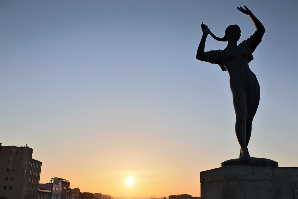 夏の像のシルエットに夕陽