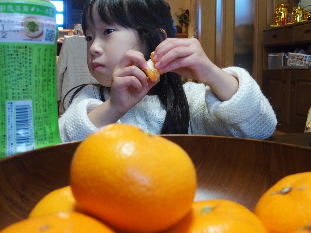 みかんを剥く少女