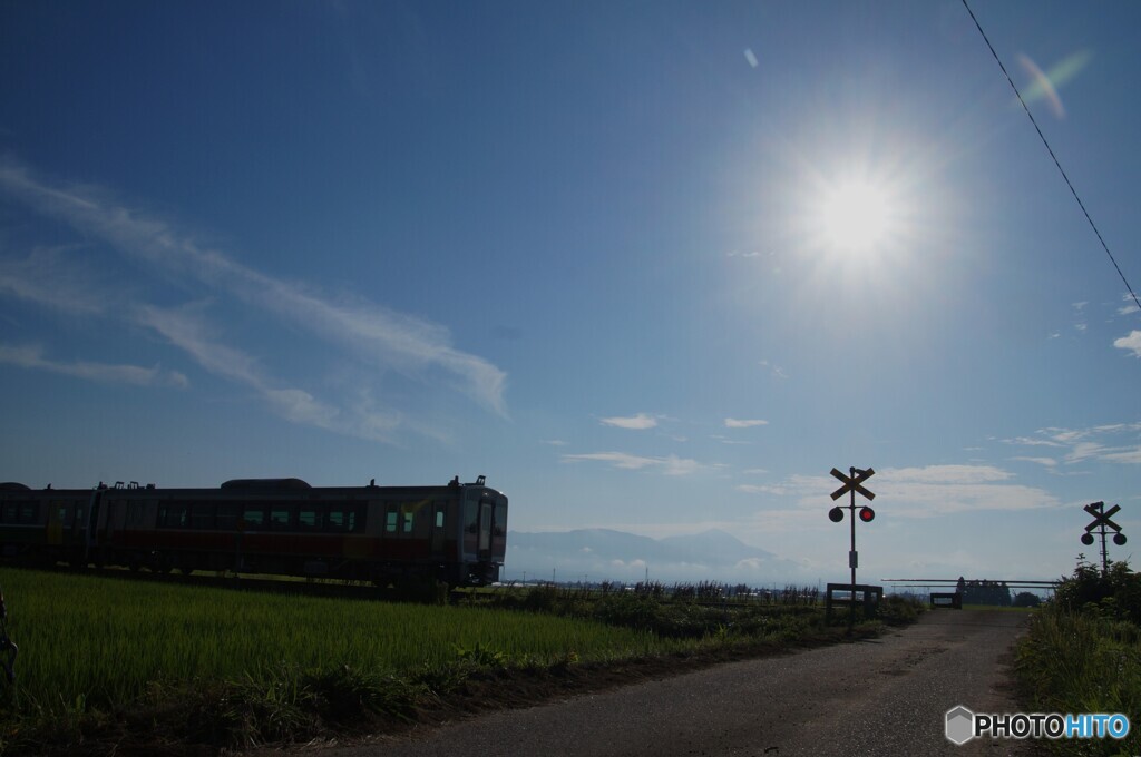 日の出の太陽と踏切がある情景！