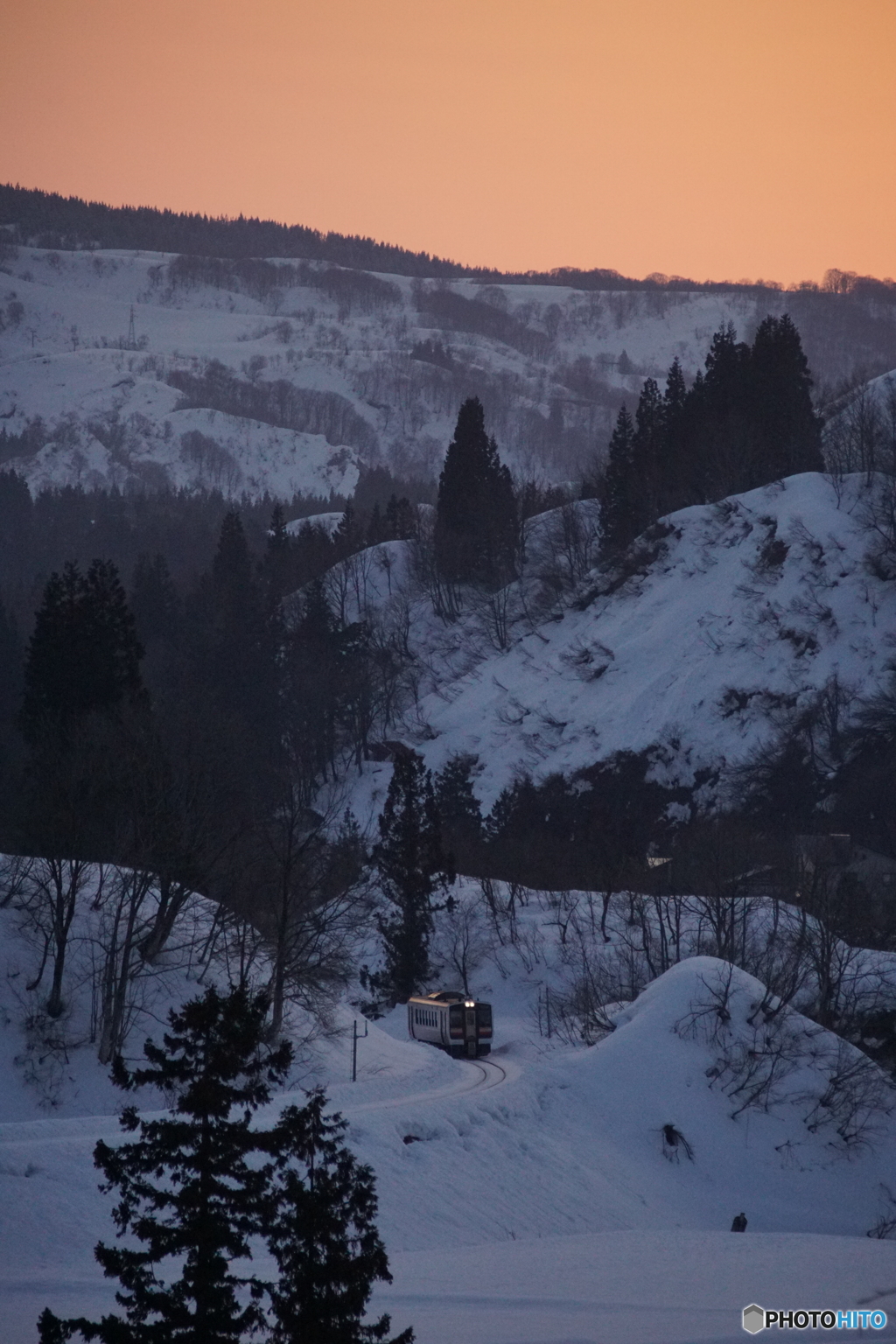 夕焼けの雪原に列車が…