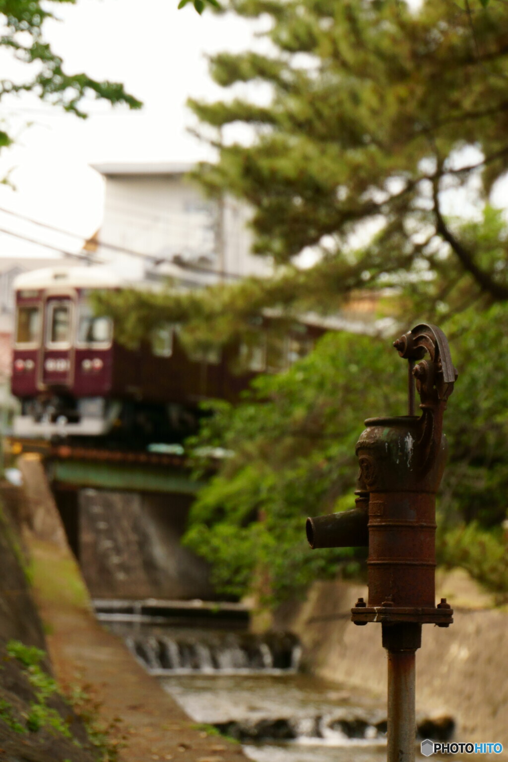 古井戸ポンプと鉄道風景