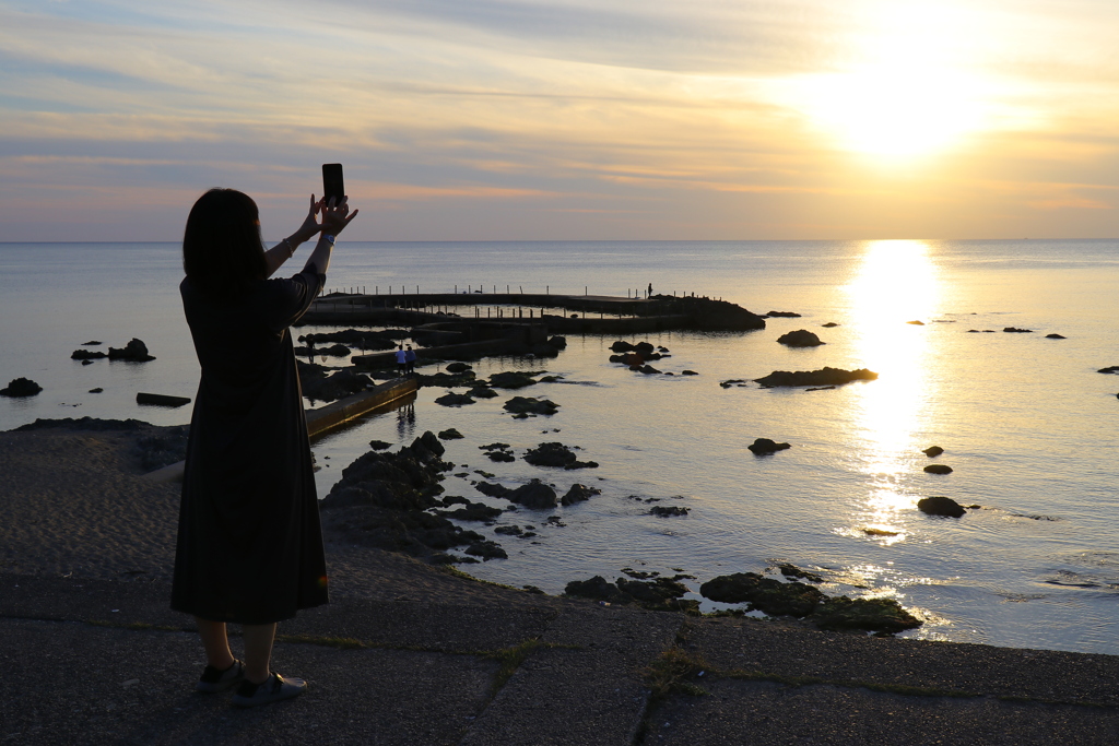 日本海夕日の丘公園から④　夕日を撮影する女性