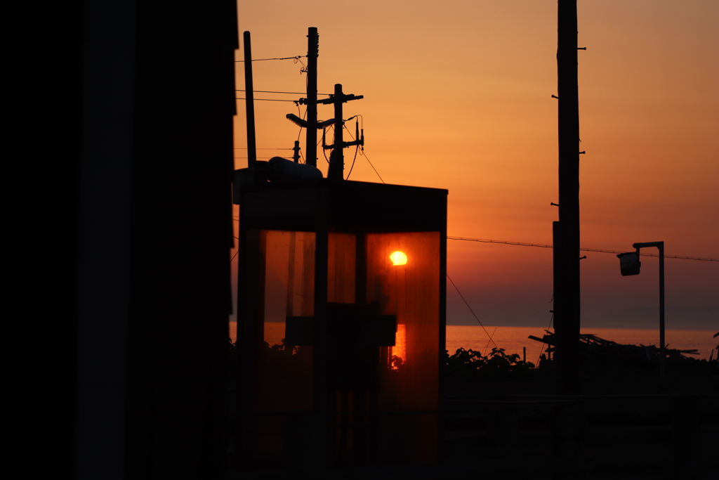 電話ボックス越しの夕陽